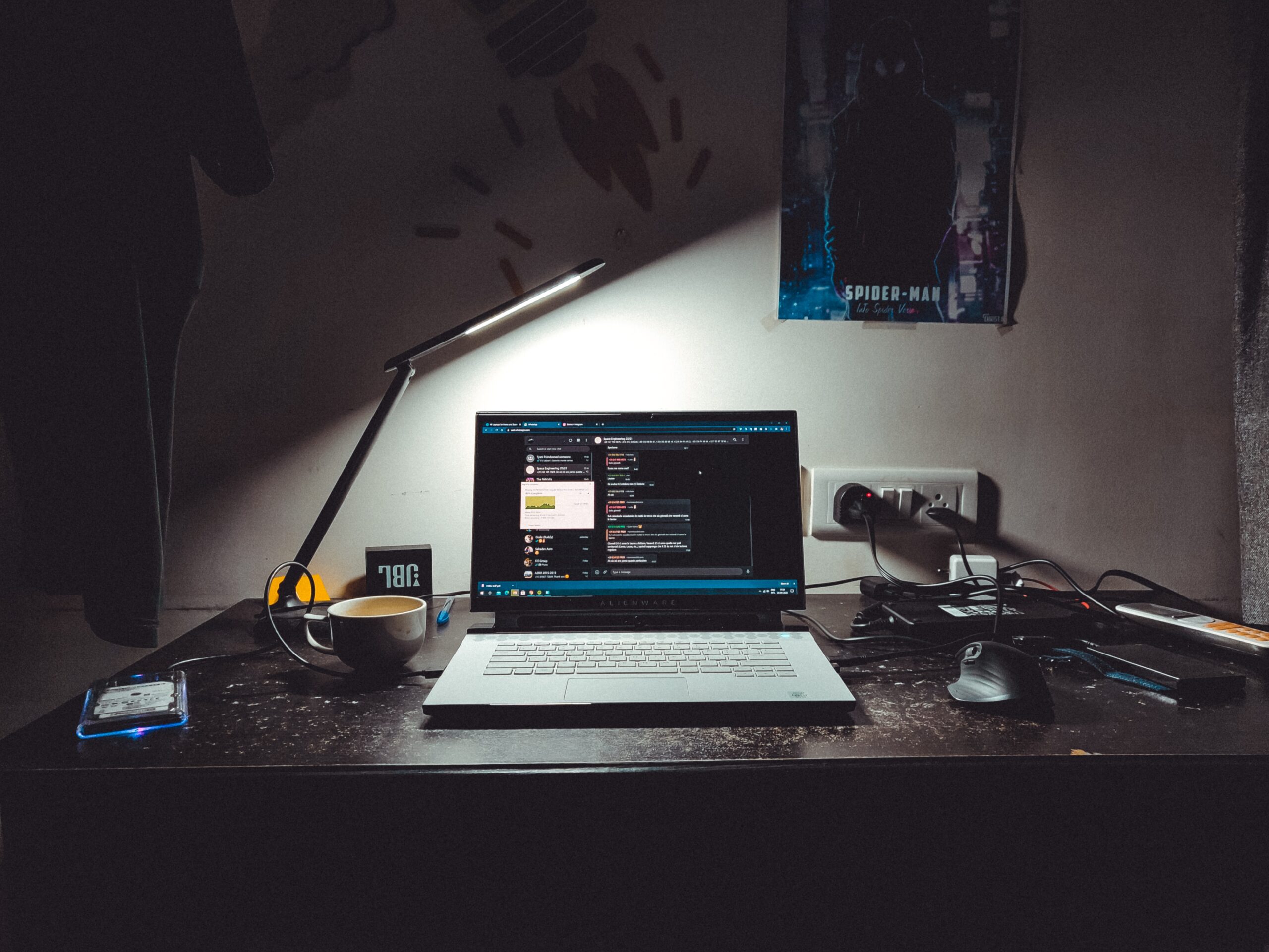 Open laptop on a desk, illuminated by a lamp